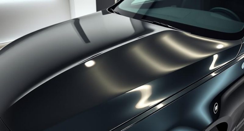 Nupoliruotas automobilio kapotas su atspindžiu, rodančiu paviršiaus blizgesį
